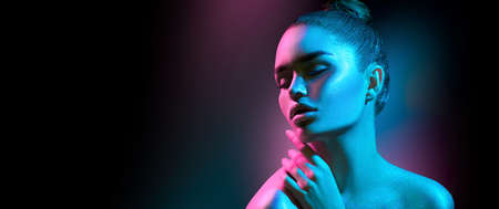 High Fashion model woman in colorful bright sparkles and neon lights posing in studio, portrait of beautiful sexy girl, trendy glowing make-up. Art design. Colorful make up. Glitter Vivid neon makeupの写真素材