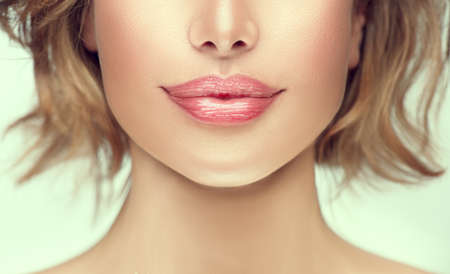 Beautiful young woman's lips closeup. Plastic surgery, fillers, injection. Part of the model girl face, youth concept. Perfect healthy skin. Natural make-up. Chin. Youth and beauty. Health careの写真素材