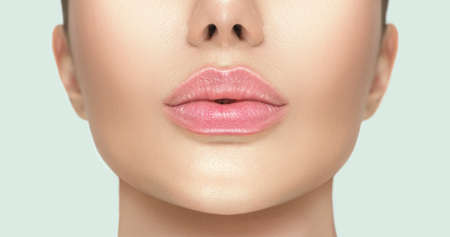 Beautiful young woman's lips closeup. Plastic surgery, fillers, injection. Part of the model girl face, youth concept. Perfect healthy skin. Natural make-up. Chin. Youth and beauty. Health careの写真素材