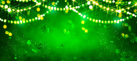 St. Patrick's Day abstract green background decorated with shamrock leaves. Patrick Day pub party celebrating. Abstract Border art design magic backdrop. Widescreen clovers on black with copy spaceの写真素材