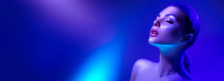 High Fashion model woman in colorful bright neon lights posing in studio, night club. Portrait of beautiful girl in UV. Art design colorful make up. On colourful vivid background, art design.の写真素材