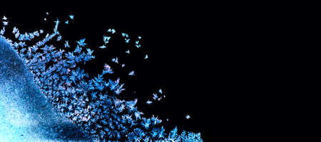 Frozen winter window. Window frozen glass, ice crystals. Snow frame. Beautiful Hoarfrost pattern, rime on black background. Christmas or New Year backdrop for screen mode use.の写真素材