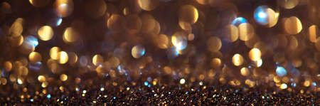 Christmas golden glowing background. Golden Holiday Abstract Glitter Defocused Backdrop With Blinking Stars and garlands, sparks. New year holiday glow background, bokeh. Wide screenの写真素材