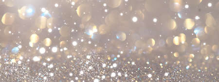 Abstract glowing gold bokeh background. Golden holiday glow backdrop. Defocused Background With Blinking Stars. Blurred Bokeh art design. Abstract shiny lights designの写真素材