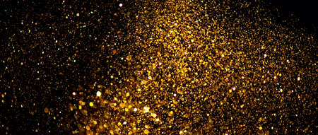 Golden sparks, Christmas and New Year glittering stars swirl on black bokeh background, backdrop with sparkling gold, holiday garland, magic glowing dust, lights. Gold Abstract Gliの写真素材