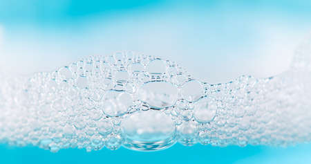 foam. Soap foam popping bubbles background. Soap sud macro structure. Soap foam close-up, blue backgroundの写真素材