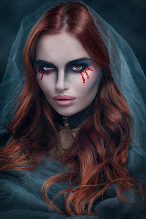 Beautiful witch or vampire woman in a veil. Dark portrait of beauty model with dripping blood make up, Halloween art. Mysterious model girlの写真素材