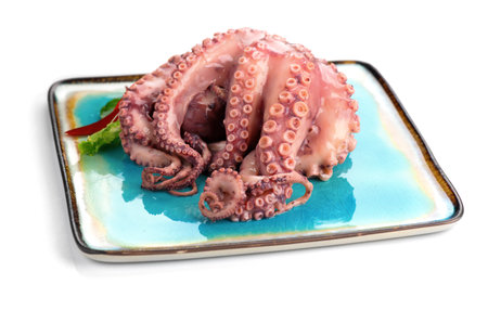 Octopus serving with vegetables, sea food. Freshly boiled octopus on a blue plate, Mediterranean cuisine, dinner. Isolated on white background, closeupの写真素材
