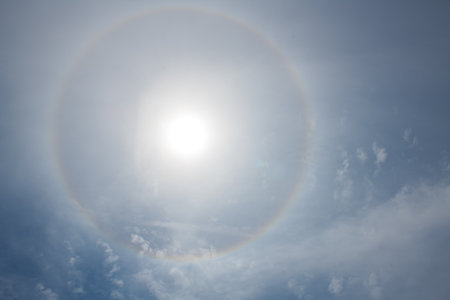 Sun halo with clouds on a blue sky, nature background. Circular Optical phenomenonの写真素材