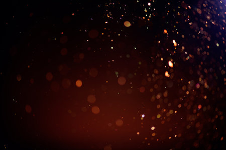 Golden sparks, Christmas and New Year floating littering stars on black bokeh background, backdrop with sparkling gold holiday garland, magic dust, lights. Gold Abstract Glitter Blの写真素材