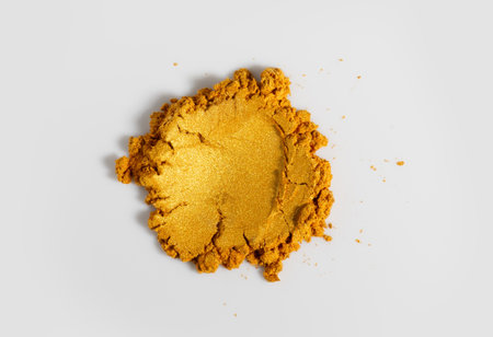 Gold powder isolated on white background. Golden metallic dry paint rotating, close up. Cosmetic, shimmer, art paint. Texture of gold metal powder close upの写真素材