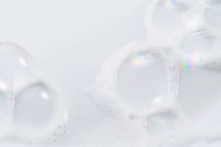 Foam bubbles background. Soap foam bubble, white backdrop. Soap sud macro structure. Bath. Soap foam close-up. Clean, cleaning concept, laundry, shower gel, shampooの写真素材