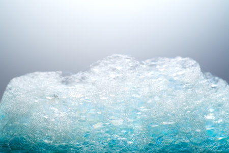Foam texture close up. Soap foam bubbles background. Soap sud macro structure, close-up, on blue background , macro shotの写真素材