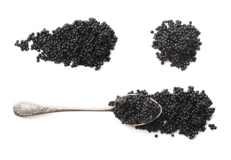 Black Caviar isolated on white background, top view. Set of sturgeon black caviar close-up. Delicatessen. Texture of expensive luxury caviar in Silver spoonの写真素材