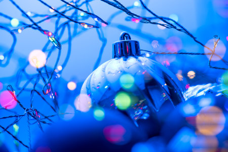 Christmas and New Year blue color baubles decoration background with colourful lights of garlands. Art design with holiday ball. Beautiful Christmas balls closeup. Xmas backdrop.の写真素材