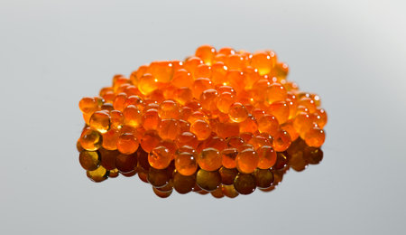 Red caviar close up. Salmon caviar rotating over gray background. Delicious gourmet food.  Delicatessen. Texture of caviar. Seafood, macro shot.の写真素材