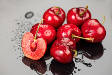 Cherries on gray background. Fresh ripe Cherry berries close-up. Organic red cherries with water drops on grey background. Heap of juicy organic Berries, vegan food. Top view.の写真素材