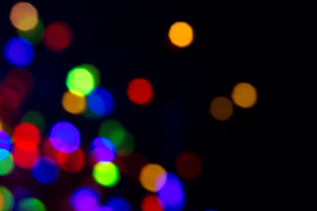 Glowing defocused colorful Christmas garland on black background. Border design Garland colourful lights, Holiday colourful backdrop. Xmas lightsの写真素材
