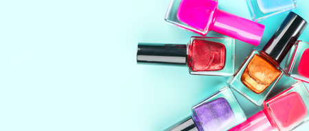 Nail polish colorful bottles. Manicure concept. Top view. Nailpolish colourful bottles over blue background, vertical backdrop. Nail polish red, pink, violet colors shellac UV gel,の写真素材