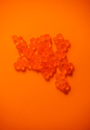 Red Caviar macro shot, Caviar over orange background. Fish roe, Close-up salmon or trout caviar. Delicatessen. Gourmet food. Texture of caviar. Seafood vertical shotの写真素材