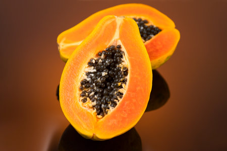 Papaya fruit on brown background. Fresh organic Papaya exotic fruits close up. Healthy vegan papayasの写真素材