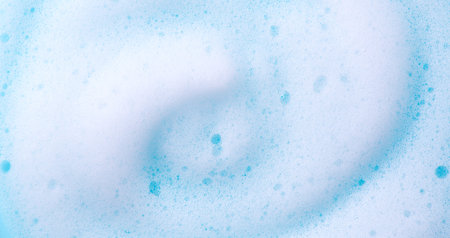 Foam swirl background. Liquid soap bubbles, Froth bubbles backdrop. Soap foam white backdrop. Soap sud macro structure close-up. Clean, cleaning, washing, laundry. Top view.の写真素材