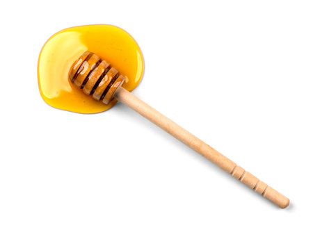 Honey with wooden honey dipper isolated on white background. Spilled honey. Honey Spoon, drizzler, stick. Top view. Flat lay.の写真素材