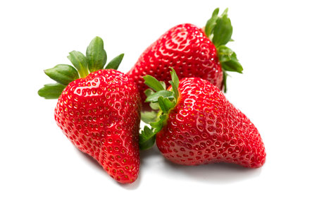 Strawberry isolated on white background. Three Fresh ripe organic strawberries, macro shot of fresh juicy berries, top view, close upの写真素材