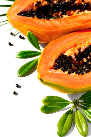 Papaya fruit isolated on white background, fresh exotic fruits with leaves and seeds border design. Halved fresh organic sweet Papaya exotic fruit art design, close up. Top view, vの写真素材