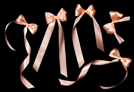 Pastel color satin gift bow set isolated on black background. Holiday decoration silk ribbon. Pink gift design. Various ribbons, bowsの写真素材