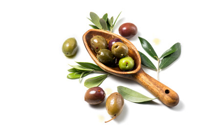 Olives, homemade marinated colorful olives with herbs and spices isolated on white background, in a rustic wooden spoon, close up. Healthy Mediterranean vegan foodの写真素材