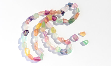 Fluorite natural colorful stones, mineral, beads of bracelet, necklace isolated on white background. Fluorspar stone gems, set of natural mineral stones, beautiful gemstones. Top vの写真素材