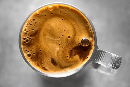Coffee cup from above, Espresso foam texture, creamy coffee, rich, freshly brewed cup of hot latte. Top view of cappuccino milk foam closeup. Creamy coffee macro shot, on a grey taの写真素材