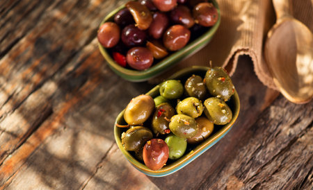 Olives, homemade marinated colorful olives with herbs and spices on rustic table, close up. Healthy Mediterranean vegan food. Vertical image, top view, flat lay.の写真素材