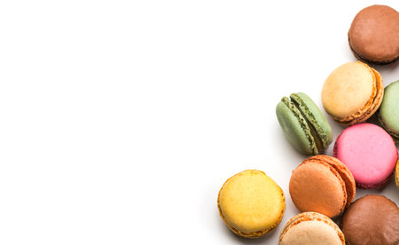 Macarons, macaroons, colorful assortment border design, vibrant pink, yellow, green, brown French pastries creamy fillings, macaroon isolated on white background, flat lay, top vieの写真素材