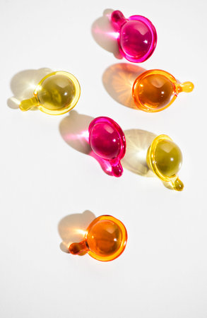 Cosmetic capsules for face or hair care, colorful liquid-filled capsules, oil, serum, pink and...
