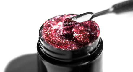 Beauty glitter pink nail polish UV gel. Pink color Nailpolish liquid surface, shellac UV gel texture, varnish, manicure salon concept. Isolated on white background.の写真素材