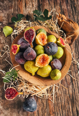Fig fruits over wood background. Ripe sweet fresh figs fruit with leaf close up. Vertical image.の写真素材