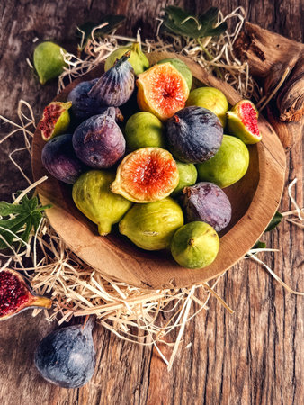Fig fruits over wood background. Ripe sweet fresh figs fruit with leaf close up, flat lay, top view. Vertical image.の写真素材