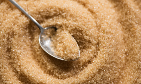 Brown Cane sugar in a spoon close up. Healthy eating, diet concept. Brown sugar background, texture. Top view, flat lay, food backdropの写真素材