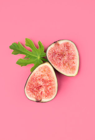 Fig fruits. Ripe sweet fresh figs fruit with leaf close up, on pink background, flat lay, top view.の写真素材