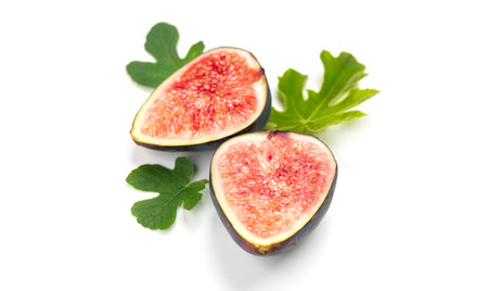 Fig fruits. Half of Ripe sweet fresh figs fruit with leaves close up, isolated on white background, flat lay, top viewの写真素材