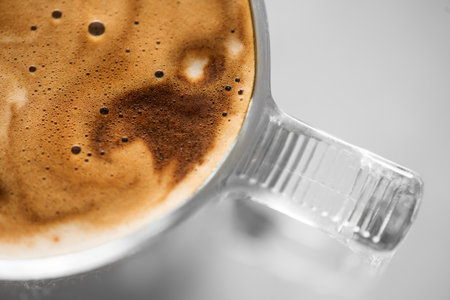 Coffee cup from above, Espresso foam texture, creamy coffee, rich, freshly brewed cup of hot latte. Top view of cappuccino milk foam closeup. Creamy coffee macro shot, on a grey taの写真素材