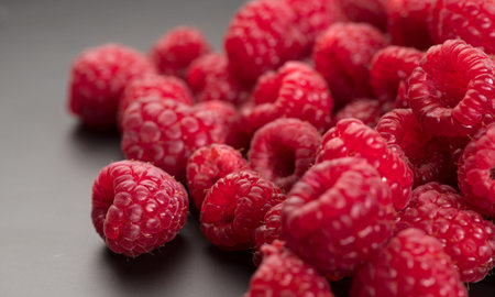 Raspberry fresh berries close up, ripe fresh organic Raspberries over black background, macro shot....