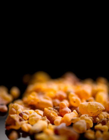 Frankincense olibanum resin, Boswellia sacra Isolated on black background. Frankincense or olibanum aromatic resin used in incense and perfumes, border design, macro shot, verticalの写真素材
