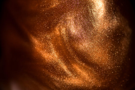 Photo of Gold particles floating background, Liquid gold, golden abstract backdrop. Beautiful metallic yellow dust texture, Metallic paint close-up. Art Wallpaper waves surface.の写真素材