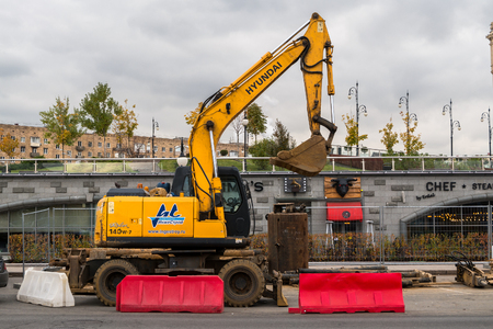 MOSCOW, RUSSIA - OCTOBER 24, 2017: Yellow wheel excavator Hyundai, working in urban environment next to the hotel "Ukraine".のeditorial素材