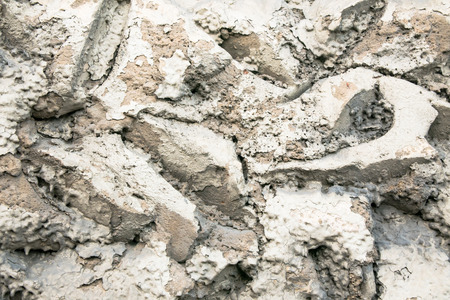 Close up of a rough textured plaster wall coating, imitation of stone masonry. Abstract grey patchy background.の写真素材