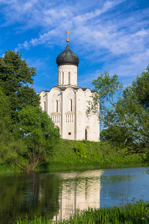 UNESCO World Heritage site. Architectural monument of the 12 century. Church of the Intercession of the Holy Virgin on the Nerl River. View from the opposite river shore on the bright summer day. Vladimir region, Russia.の写真素材