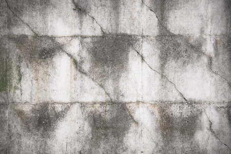 Close-up of rough texture of aged gray concrete wall with geometric pattern relief, with dirty flow marks.の写真素材